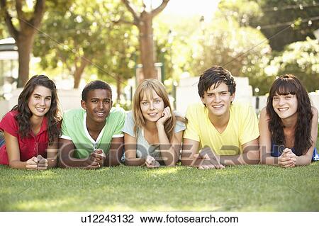 Stock Image - Group Of Teenagers Lying On Stomachs In Park. Fotosearch