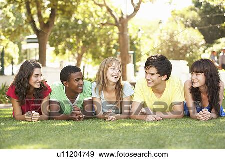 Group Of Teenagers Lying On Stomachs In Park View Large Photo Image Stock Photo - Group Of Teenagers Lying On Stomachs In Park. Fotosearch