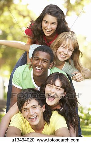 Stock Image - Group Of Teenagers Piled Up In Park. Fotosearch