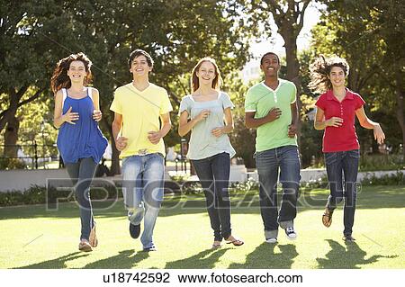 Stock Image - Group Of Teenagers Running Through Park. Fotosearch
