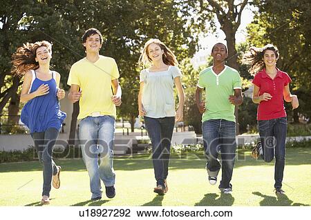 Stock Image - Group Of Teenagers Running Through Park. Fotosearch