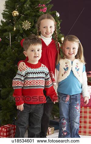 Group Of Young Children With Presents In Front Of Christmas Tree View Large Photo Image Stock Image - Group Of Young Children With Presents In Front Of Christmas Tree. Fotosearch