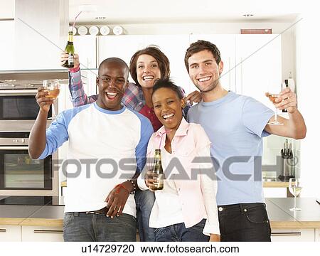 Group Of Young Friends Enjoying Drink In Modern Kitchen View Large Photo Image Stock Image - Group Of Young Friends Enjoying Drink In Modern Kitchen. Fotosearch