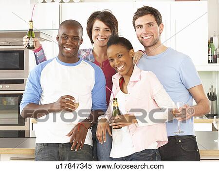 Group Of Young Friends Enjoying Drink In Modern Kitchen View Large Photo Image Stock Photography - Group Of Young Friends Enjoying Drink In Modern Kitchen. Fotosearch