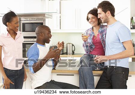 Group Of Young Friends Enjoying Glass Of Wine In Modern Kitchen View Large Photo Image Picture - Group Of Young Friends Enjoying Glass Of Wine In Modern Kitchen. Fotosearch