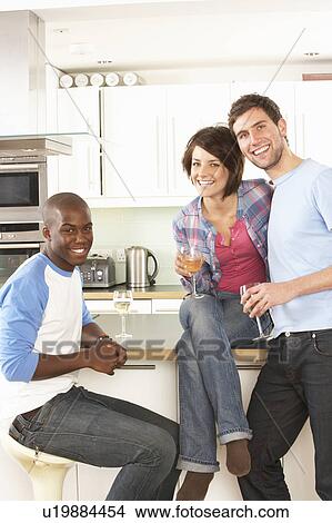 Group Of Young Friends Enjoying Glass Of Wine In Modern Kitchen View Large Photo Image Picture - Group Of Young Friends Enjoying Glass Of Wine In Modern Kitchen. Fotosearch