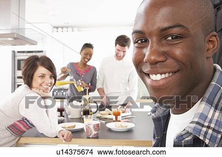 Group Of Young Friends Preparing Breakfast In Modern Kitchen View Large Photo Image Picture - Group Of Young Friends Preparing Breakfast In Modern Kitchen. Fotosearch