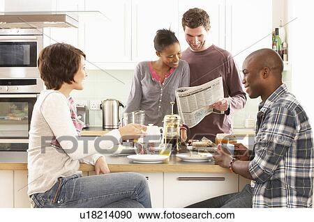 Stock Image - Group Of Young Friends Preparing Breakfast In Modern Kitchen. Fotosearch