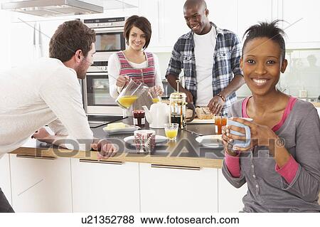 Stock Photo - Group Of Young Friends Preparing Breakfast In Modern Kitchen. Fotosearch