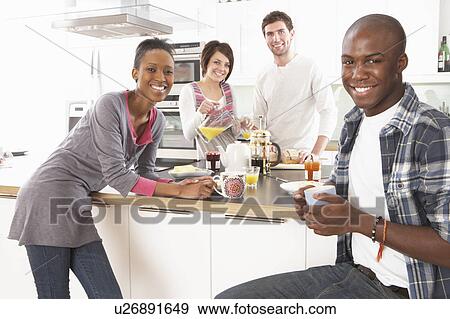 Stock Photo - Group Of Young Friends Preparing Breakfast In Modern Kitchen. Fotosearch