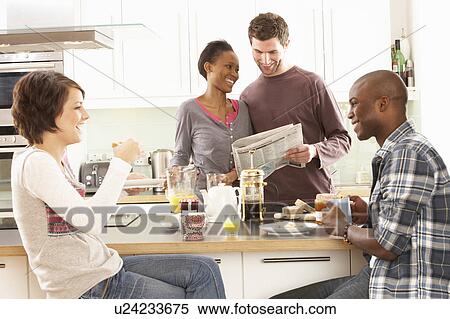 Stock Photography - Group Of Young Friends Preparing Breakfast In Modern Kitchen. Fotosearch