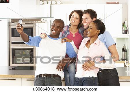 Group Of Young Friends Taking Photo In Modern Kitchen View Large Photo Image Stock Photo - Group Of Young Friends Taking Photo In Modern Kitchen. Fotosearch