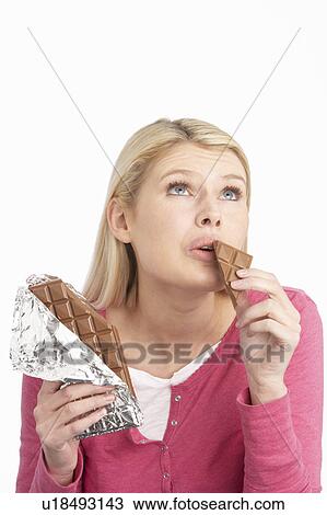 Guilty Looking Young Woman Eating Big Bar Of Chocolate In Studio View Large Photo Image Stock Image - Guilty Looking Young Woman Eating Big Bar Of Chocolate In Studio. Fotosearch