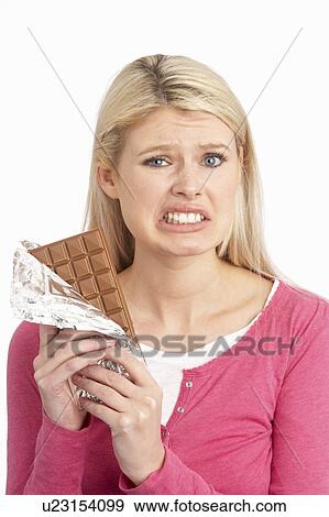 Guilty Looking Young Woman Eating Big Bar Of Chocolate In Studio View Large Photo Image Stock Photo - Guilty Looking Young Woman Eating Big Bar Of Chocolate In Studio. Fotosearch
