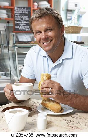Male Customer Enjoying Sandwich And Coffee In Café View Large Photo Image Stock Photo - Male Customer Enjoying Sandwich And Coffee In Café . Fotosearch