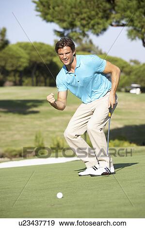 Stock Photo - Male Golfer On Golf Course Putting On Green. Fotosearch