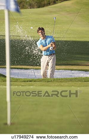 Picture - Male Golfer Playing Bunker Shot On Golf Course. Fotosearch