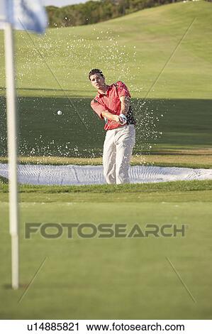 Stock Image - Male Golfer Playing Bunker Shot On Golf Course. Fotosearch