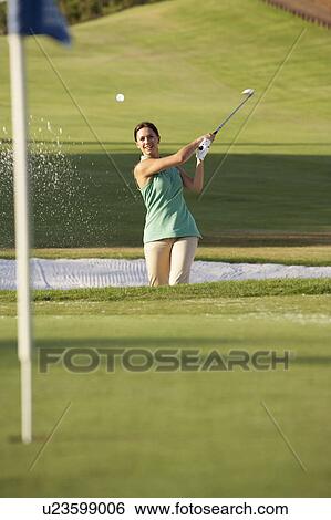 Stock Photograph - Male Golfer Playing Bunker Shot On Golf Course. Fotosearch