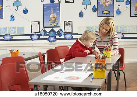 Male Primary School Pupil And Teacher Working At Desk In Classroom View Large Photo Image Stock Image - Male Primary School Pupil And Teacher Working At Desk In Classroom. Fotosearch