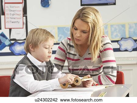 Male Primary School Pupil And Teacher Working At Desk In Classroom View Large Photo Image Stock Image - Male Primary School Pupil And Teacher Working At Desk In Classroom. Fotosearch