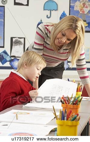 Male Primary School Pupil And Teacher Working At Desk In Classroom View Large Photo Image Stock Photo - Male Primary School Pupil And Teacher Working At Desk In Classroom. Fotosearch