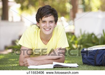 Stock Photograph - Male Teenage Student Studying In Park. Fotosearch