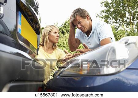Stock Image - Man And Woman Having Argument After Traffic Accident. Fotosearch