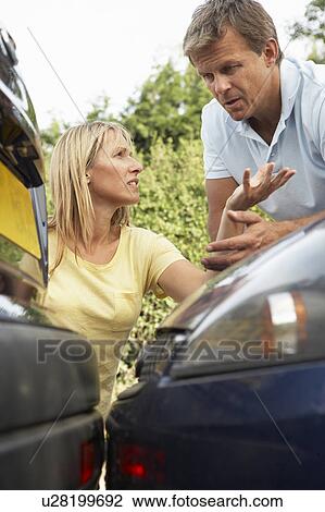 Stock Image - Man And Woman Having Argument After Traffic Accident. Fotosearch