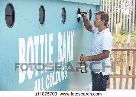 Stock Photo - Man At Recycling Centre Disposing Of Glass At Bottle Bank. Fotosearch
