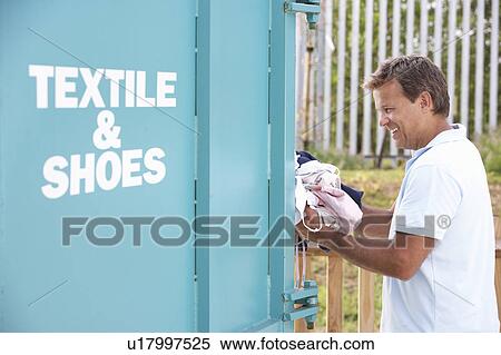 Man At Recycling Centre Disposing Of Clothing View Large Photo Image Stock Photography - Man At Recycling Centre Disposing Of Clothing. Fotosearch
