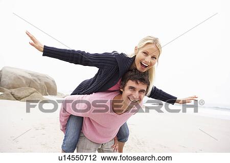 Man Giving Woman Piggyback On Winter Beach View Large Photo Image Stock Image - Man Giving Woman Piggyback On Winter Beach. Fotosearch