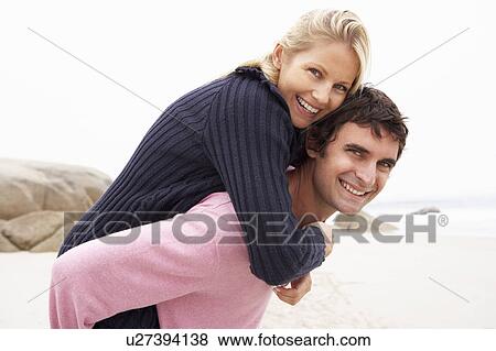 Man Giving Woman Piggyback On Winter Beach View Large Photo Image Stock Photo - Man Giving Woman Piggyback On Winter Beach. Fotosearch