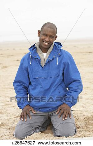 Man Relaxing On Beach In Autumn Clothing View Large Photo Image Stock Photo - Man Relaxing On Beach In Autumn Clothing. Fotosearch