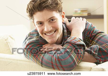 Man Relaxing On Sofa At Home View Large Photo Image Stock Image - Man Relaxing On Sofa At Home. Fotosearch