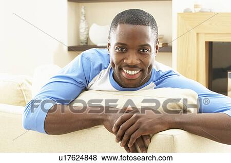Stock Photo - Man Relaxing On Sofa At Home. Fotosearch