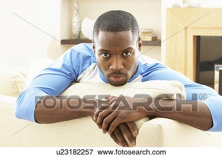 Stock Photo - Man Relaxing On Sofa At Home. Fotosearch