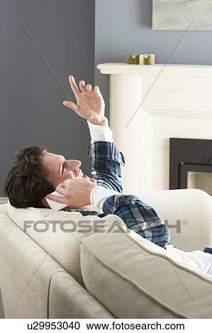 Man Relaxing Sitting On Sofa At Home Talking On Phone View Large Photo Image Stock Image - Man Relaxing Sitting On Sofa At Home Talking On Phone. Fotosearch