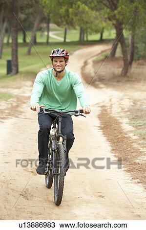 Man riding bicycle in park View Large Photo Image Stock Image - Man riding bicycle in park. Fotosearch