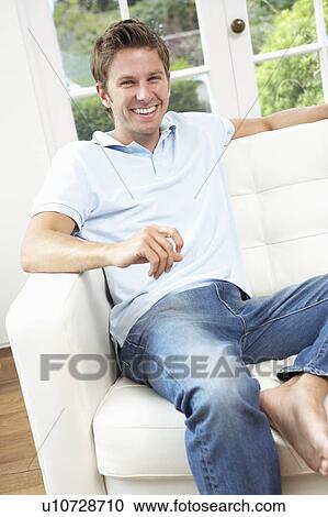 Man Sitting On Sofa Relaxing At Home View Large Photo Image Stock Image - Man Sitting On Sofa Relaxing At Home. Fotosearch