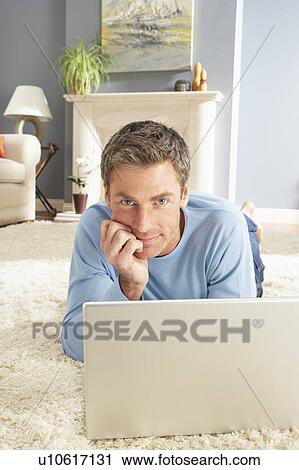 Man Using Laptop Relaxing Laying On Rug At Home View Large Photo Image Stock Image - Man Using Laptop Relaxing Laying On Rug At Home . Fotosearch