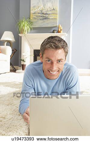 Man Using Laptop Relaxing Laying On Rug At Home View Large Photo Image Stock Image - Man Using Laptop Relaxing Laying On Rug At Home . Fotosearch