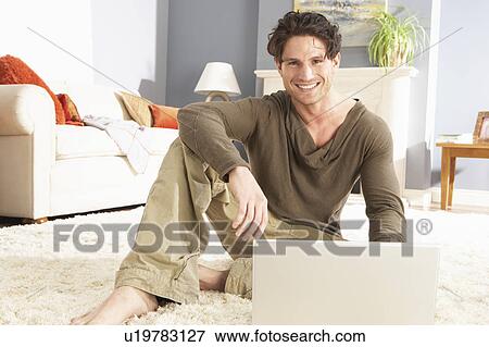 Man Using Laptop Relaxing Laying On Rug At Home View Large Photo Image Stock Photo - Man Using Laptop Relaxing Laying On Rug At Home . Fotosearch