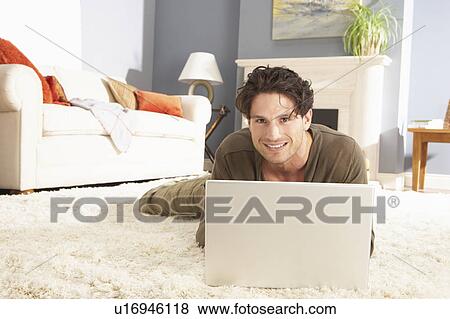 Man Using Laptop Relaxing Sitting On Rug At Home View Large Photo Image Stock Photo - Man Using Laptop Relaxing Sitting On Rug At Home . Fotosearch
