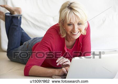 Middle age woman on her laptop computer View Large Photo Image Stock Image - Middle age woman on her laptop computer. Fotosearch