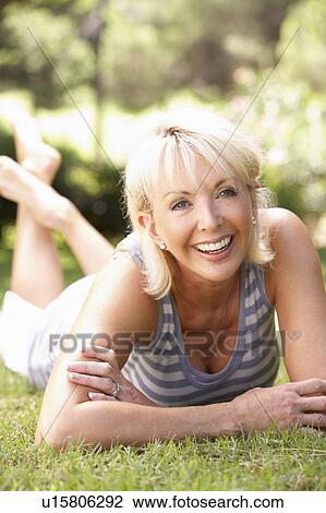 Middle age woman posing in park View Large Photo Image Stock Image - Middle age woman posing in park. Fotosearch