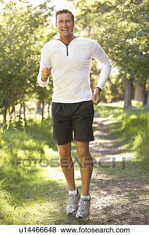 Stock Photo - Middle Aged Man Jogging In Park. Fotosearch