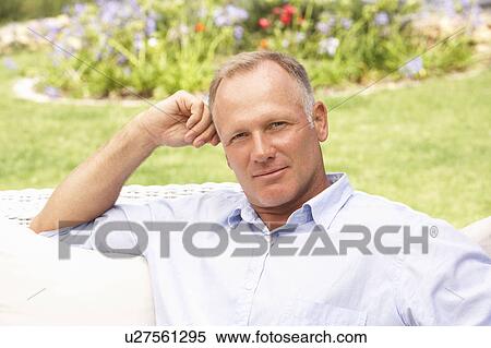 Stock Photography - Middle Aged Man Relaxing In Garden. Fotosearch