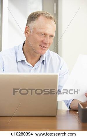 Middle Aged Man Using Laptop At Home View Large Photo Image Picture - Middle Aged Man Using Laptop At Home. Fotosearch