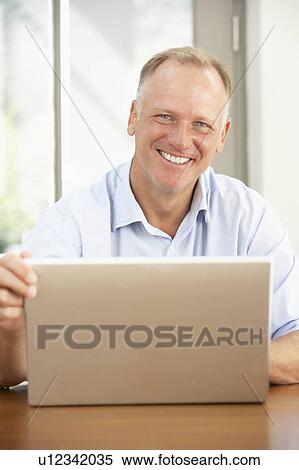 Middle Aged Man Using Laptop At Home View Large Photo Image Stock Photography - Middle Aged Man Using Laptop At Home. Fotosearch